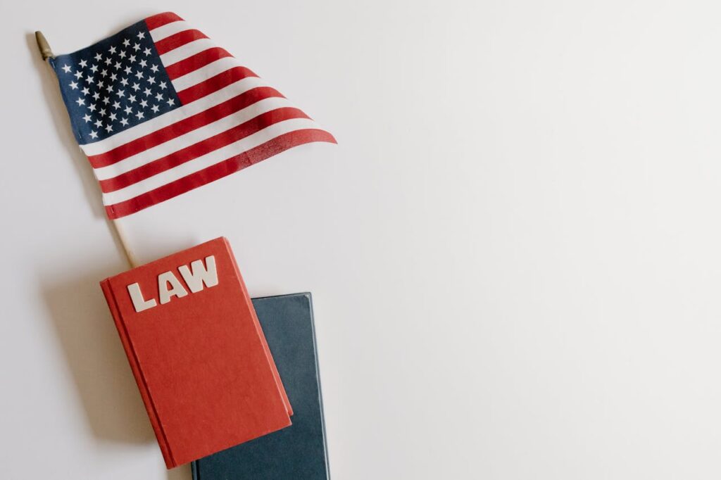 Flat lay of an American flag and a law book symbolizing justice and patriotism.